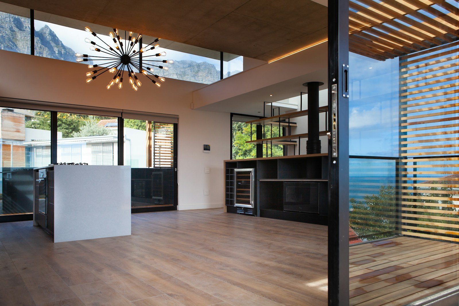 Gran apertura acristalada de marco oscuro entre interior y exterior como referencia para carpintería aluminio