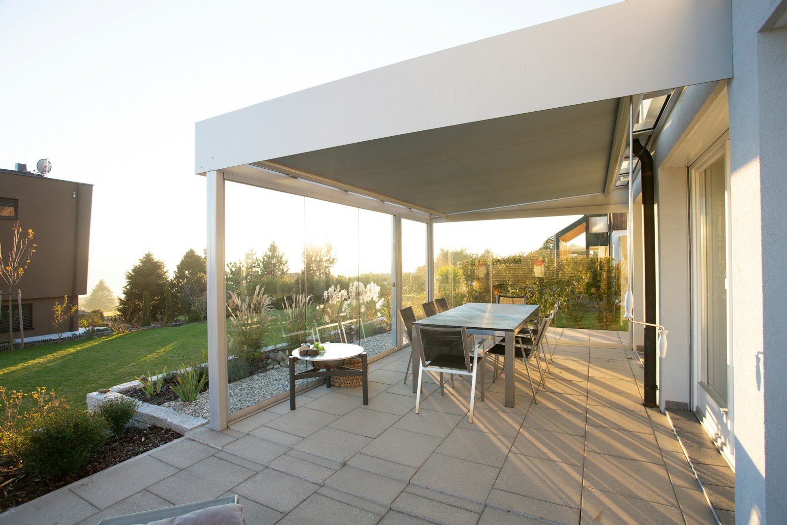 Porche cubierto con pilares claros y zona de comedor exterior
