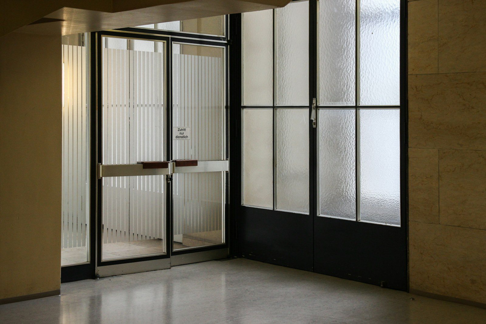Puertas dobles acristaladas con perfiles metálicos en una entrada